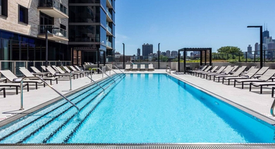 Sparkling rooftop swimming pool with comfortable lounge chairs and a breathtaking view of the Chicago skyline at North+Vine in Chicago