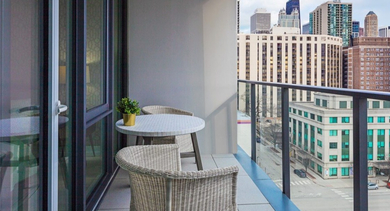 Private balcony with a small table and chairs, offering picturesque views of the Chicago city blocks at OLD TOWN PARK ONE in Chicago