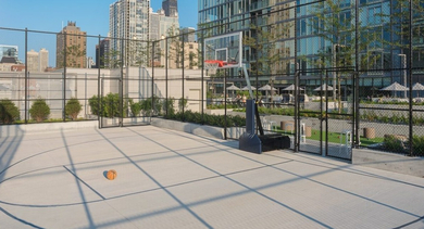 Outdoor basketball court with a vibrant orange ball and a stunning Chicago skyline backdrop at OLD TOWN PARK ONE in Chicago