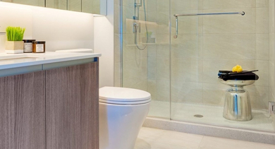 Contemporary bathroom with a spacious walk-in glass shower, floating wood vanity, and ample mirror at OLD TOWN PARK ONE in Chicago