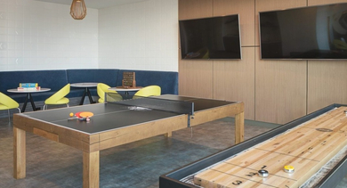 Lively game room featuring a ping-pong table, shuffleboard, and comfortable lounge seating for residents at OLD TOWN PARK ONE in Chicago