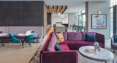 Vibrant resident lounge featuring colorful sofas, diverse seating arrangements, and a modern chandelier at OLD TOWN PARK ONE in Chicago