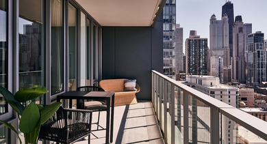 Private outdoor balcony with seating, lush greenery, and stunning panoramic views of the Chicago cityscape at OLD TOWN PARK THREE in Chicago