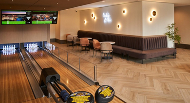 Modern bowling alley with two lanes, comfortable lounge seating, and a cozy fireplace at OLD TOWN PARK THREE in Chicago
