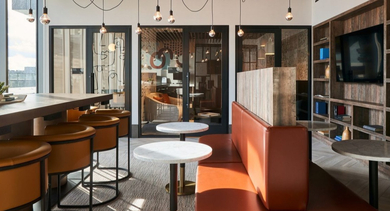 Modern co-working space with long tables, comfortable seating, private offices, and stylish lighting at OLD TOWN PARK THREE in Chicago