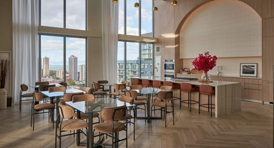 Grand private kitchen and dining area with multiple tables, bar seating, a fireplace, and city views at OLD TOWN PARK THREE in Chicago
