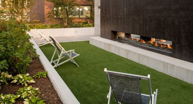 Serene courtyard with a modern outdoor fireplace and comfortable seating amidst green landscaping at OLD TOWN PARK TWO Chicago