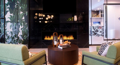 Luxurious lounge area featuring a sleek fireplace, comfortable seating, and vibrant green wall accents at OLD TOWN PARK TWO Chicago