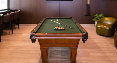 Stylish game room featuring a classic pool table, bar seating, and large screen TVs at OLD TOWN PARK TWO Chicago