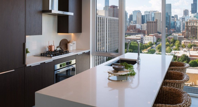 Modern kitchen with a large island, sleek cabinetry, and stunning city views from floor-to-ceiling windows at OLD TOWN PARK TWO Chicago
