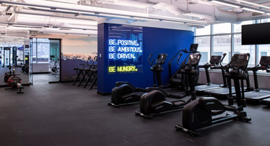 Expansive modern fitness center with cardio equipment, weight machines, and motivating wall art at OLD TOWN PARK TWO Chicago