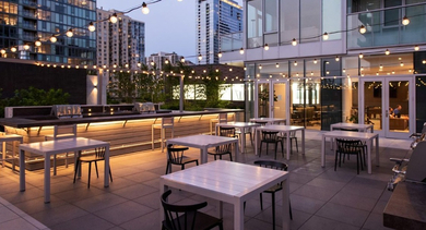 Evening view of the outdoor dining and grilling area with ambient string lights at OLD TOWN PARK TWO Chicago