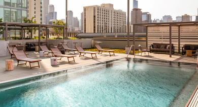 Inviting outdoor swimming pool with surrounding lounge chairs and city skyline views at OLD TOWN PARK TWO Chicago