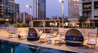 Evening view of the poolside lounge with comfortable cabanas and city lights in the background at OLD TOWN PARK TWO Chicago