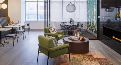 Chic resident lounge with a modern fireplace, green armchairs, and comfortable booth seating at OLD TOWN PARK TWO Chicago
