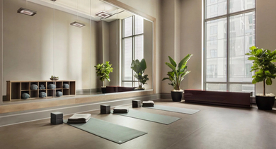 Serene yoga studio with a large mirror, yoga mats, and natural light, perfect for peaceful workouts at One Bennett Park Apartments in Chicago
