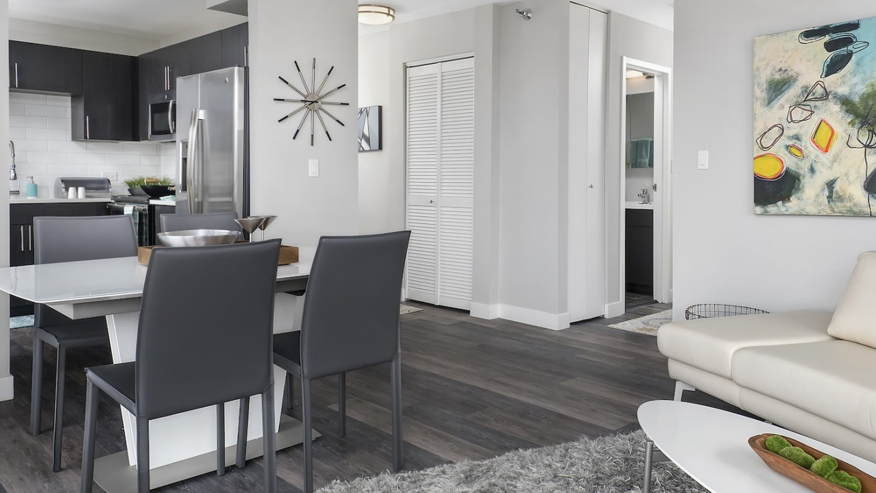 Inviting open-plan apartment featuring a cozy living area, modern dining space, and a sleek kitchen at One East Delaware Apartments