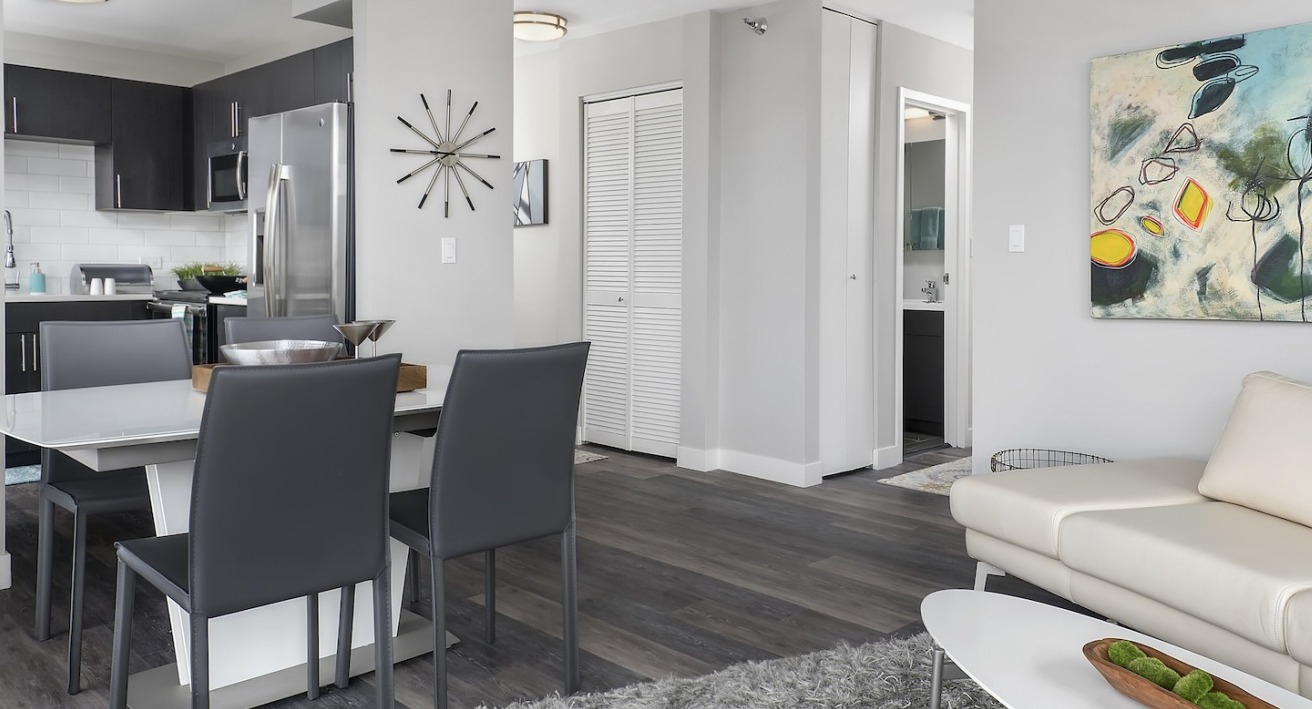 Inviting open-plan apartment featuring a cozy living area, modern dining space, and a sleek kitchen at One East Delaware Apartments