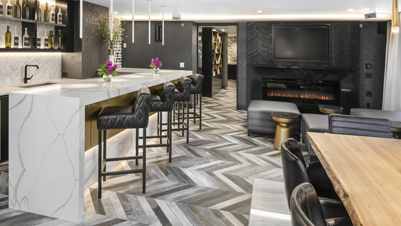 Elegant resident bar and lounge with a modern fireplace, stylish seating, and a fully stocked bar at One East Delaware Apartments