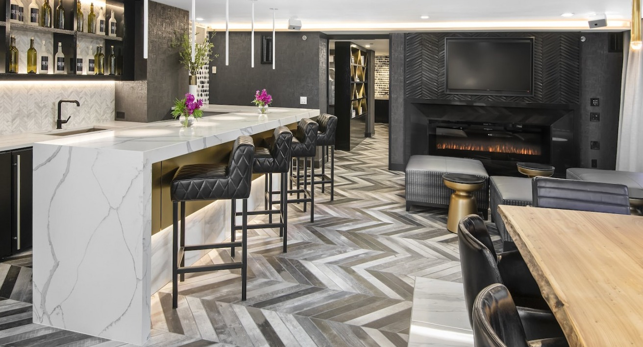 Elegant resident bar and lounge with a modern fireplace, stylish seating, and a fully stocked bar at One East Delaware Apartments