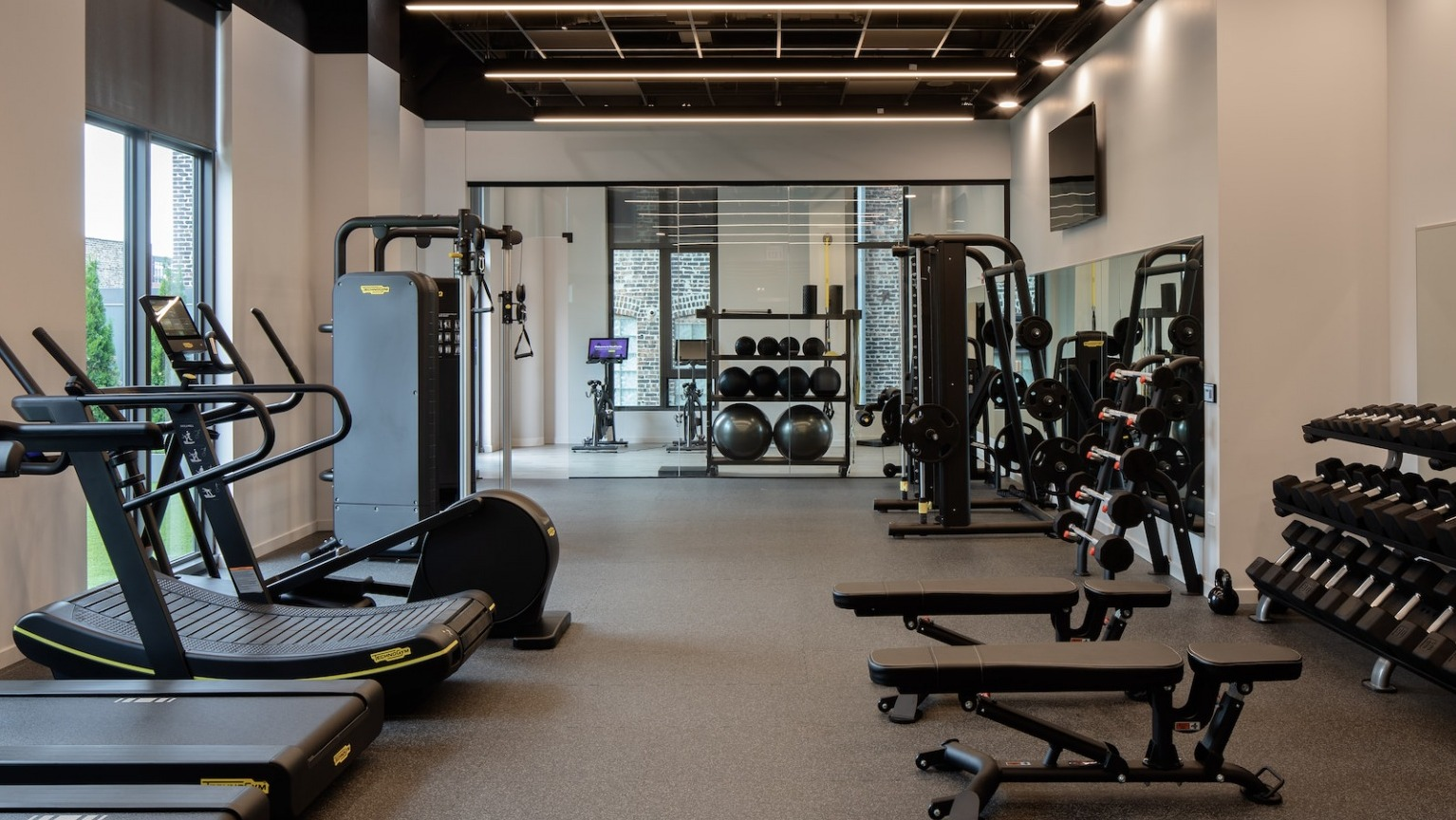 Comprehensive fitness center with various cardio machines, free weights, and strength training equipment at One Six Six
