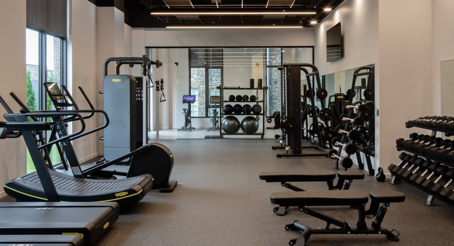 Comprehensive fitness center with various cardio machines, free weights, and strength training equipment at One Six Six