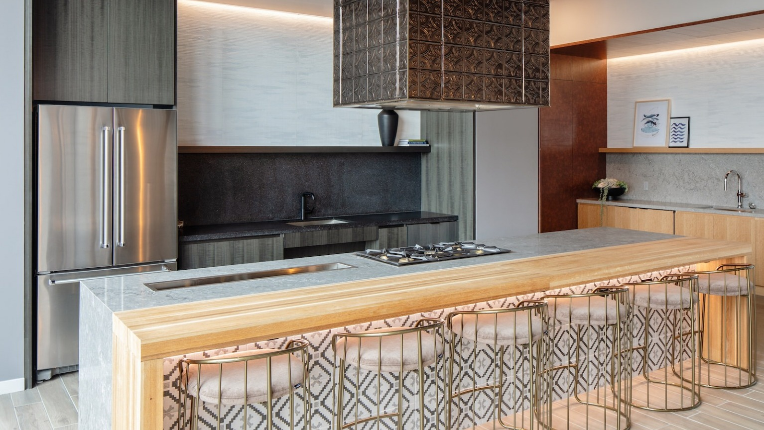 State-of-the-art gourmet kitchen with a large island, gas range, and stylish bar seating, perfect for cooking at One Six Six