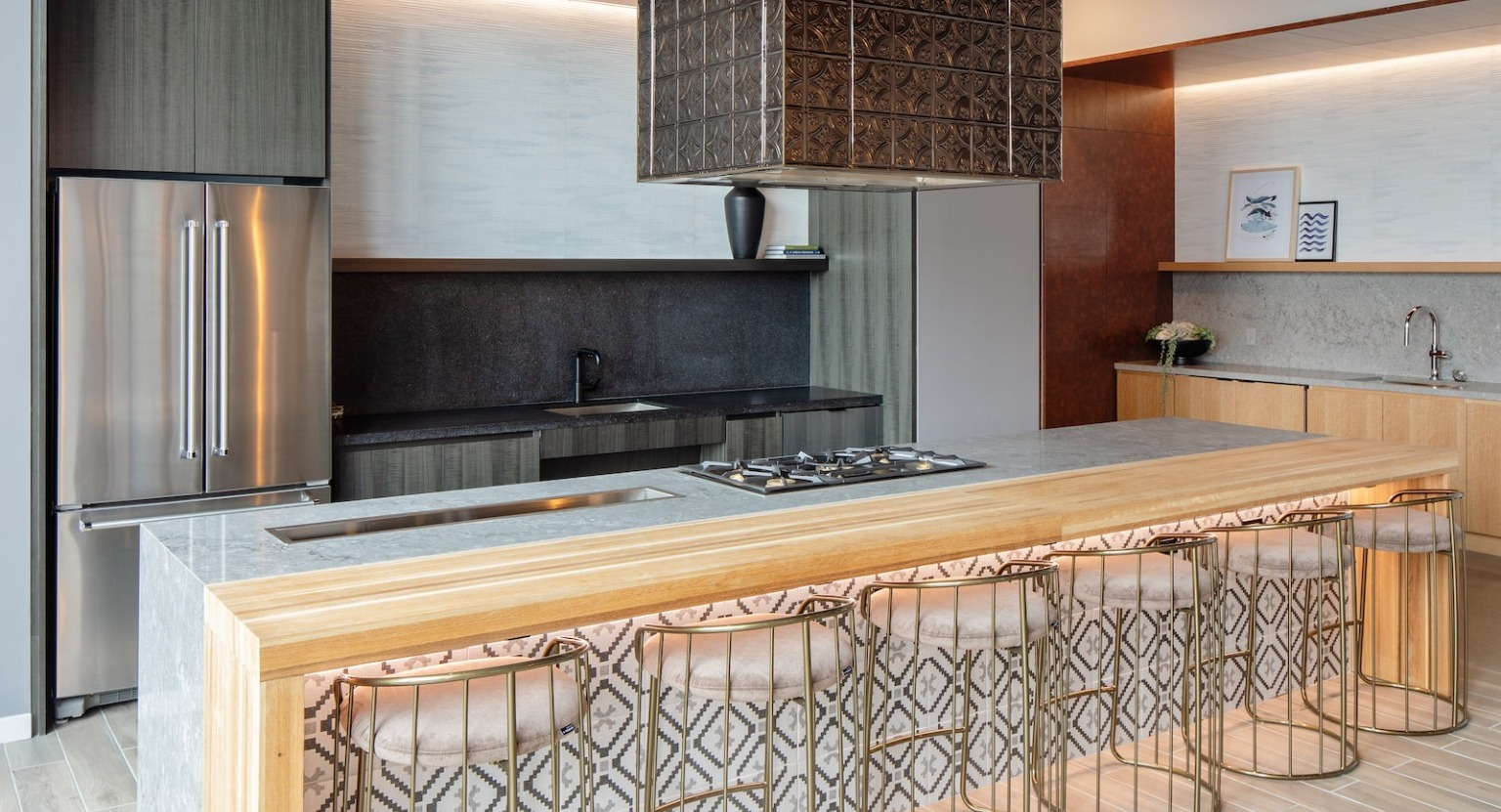 State-of-the-art gourmet kitchen with a large island, gas range, and stylish bar seating, perfect for cooking at One Six Six