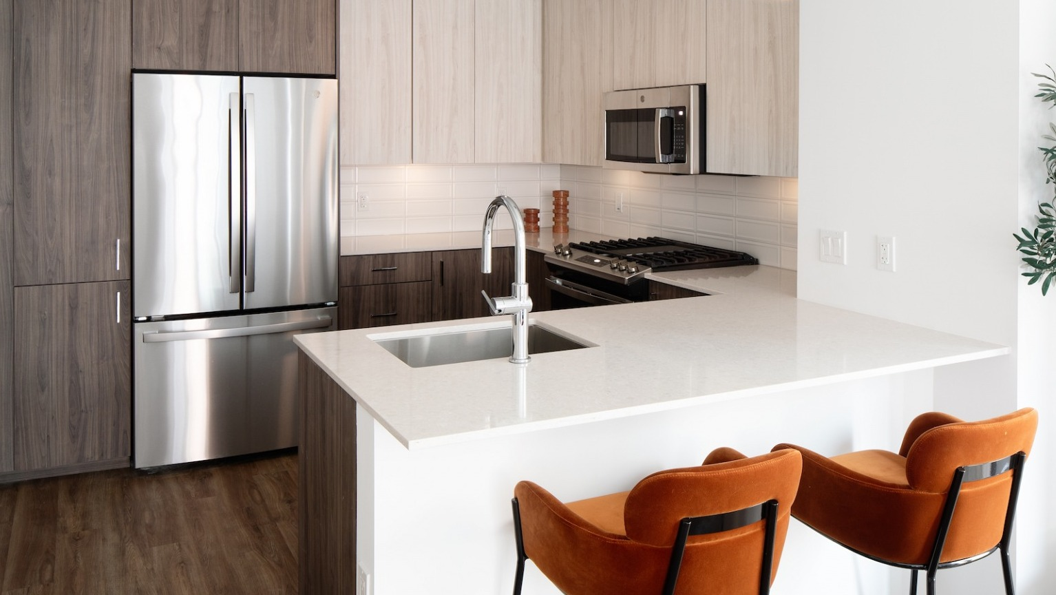 Sleek kitchen with a large island, stainless steel appliances, modern cabinetry, and ample counter space at One Six Six