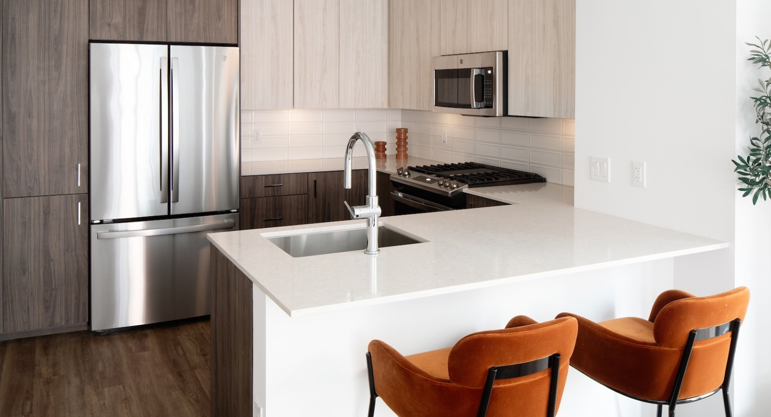 Sleek kitchen with a large island, stainless steel appliances, modern cabinetry, and ample counter space at One Six Six