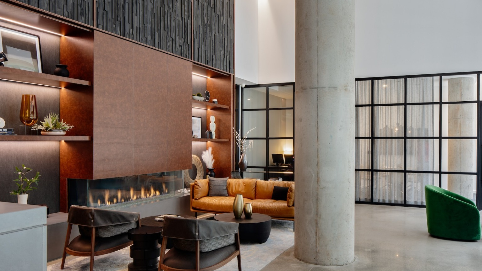 Modern resident lounge with a sleek fireplace, stylish seating, a built-in bar, and contemporary decor at One Six Six