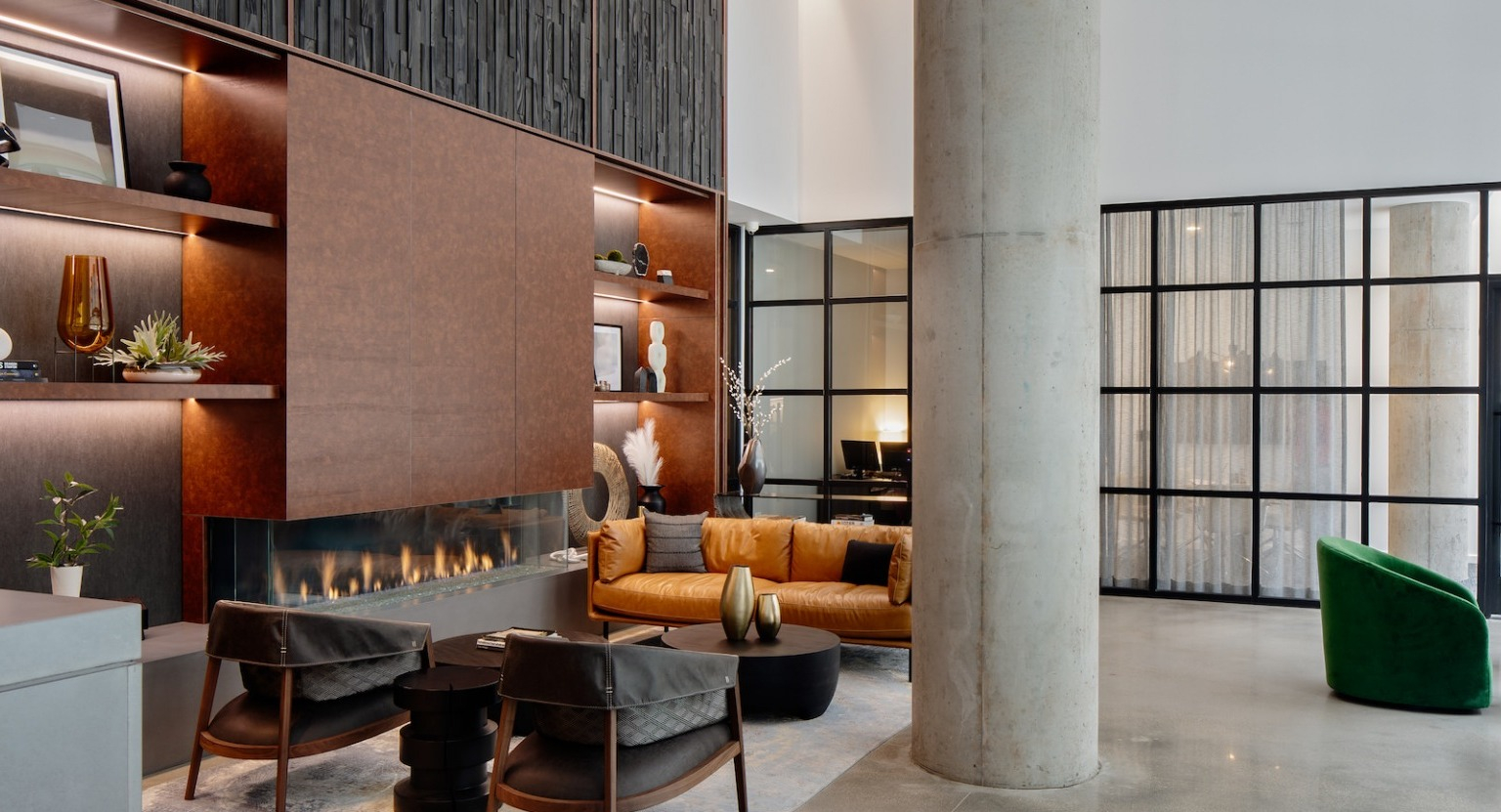 Modern resident lounge with a sleek fireplace, stylish seating, a built-in bar, and contemporary decor at One Six Six