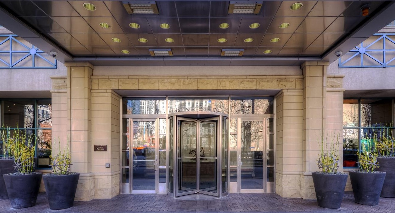 Exterior entrance with revolving doors and large potted plants at One Superior Place apartments in Chicago