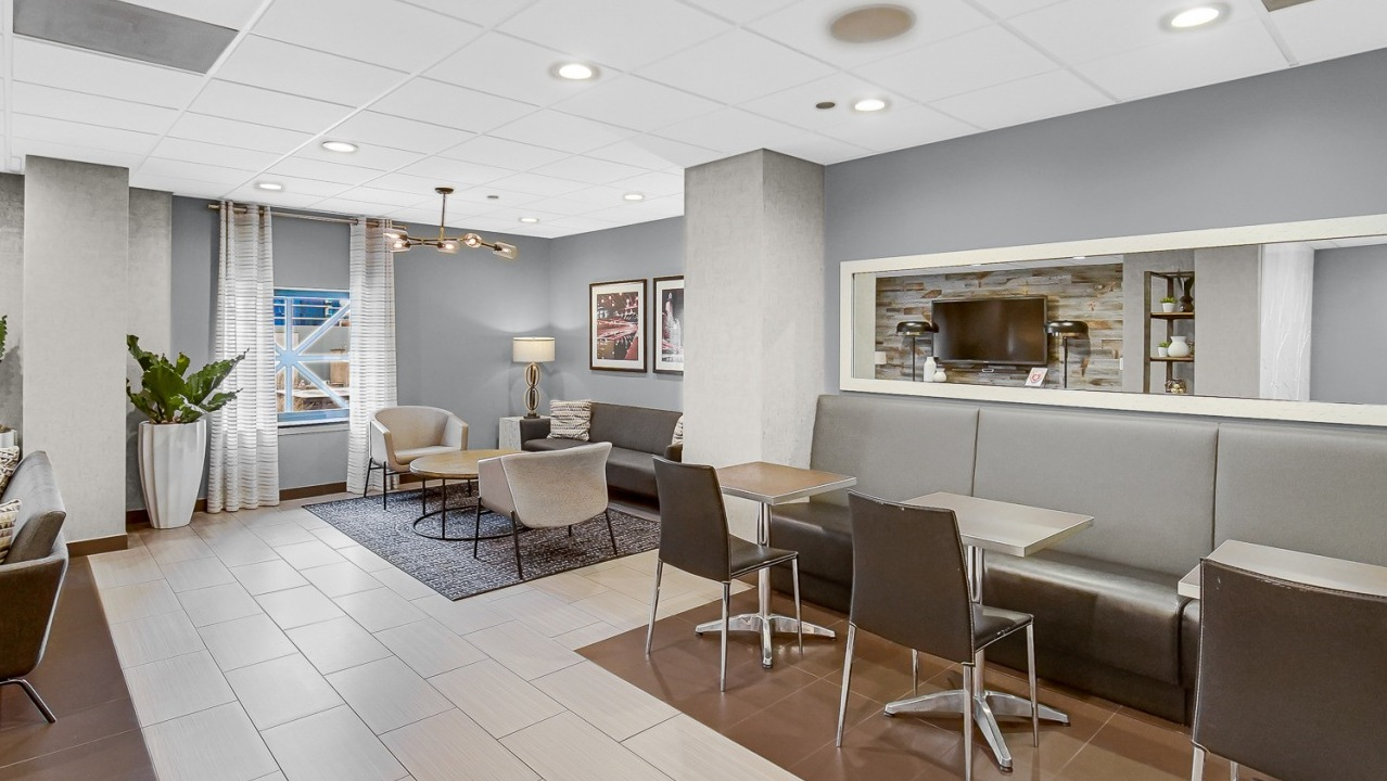 Community lounge at One Superior Place Apartments with café-style seating, modern décor, and open space for resident gatherings