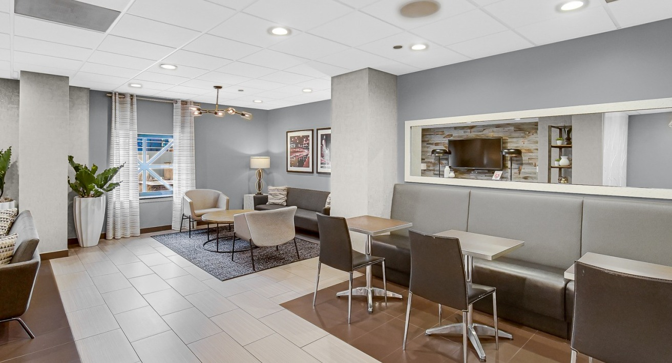 Community lounge at One Superior Place Apartments with café-style seating, modern décor, and open space for resident gatherings