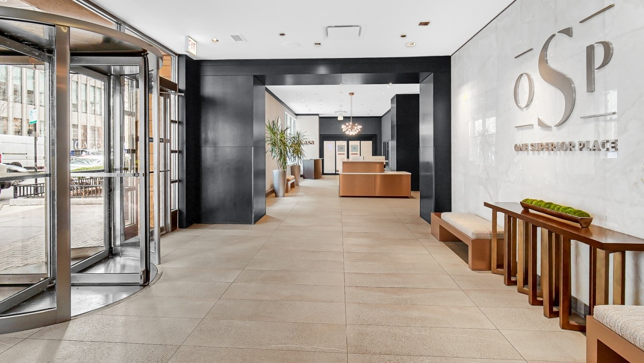 Spacious luxury lobby entrance with revolving doors and modern seating at One Superior Place apartments in Chicago