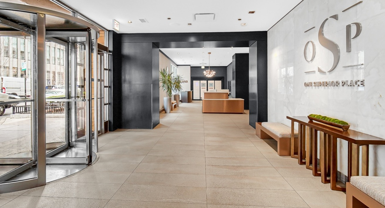 Spacious luxury lobby entrance with revolving doors and modern seating at One Superior Place apartments in Chicago