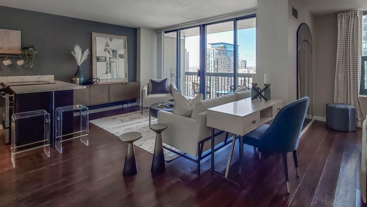 Open studio-style apartment at One Superior Place Apartments with kitchen island, living space, and bedroom area in a modern layout