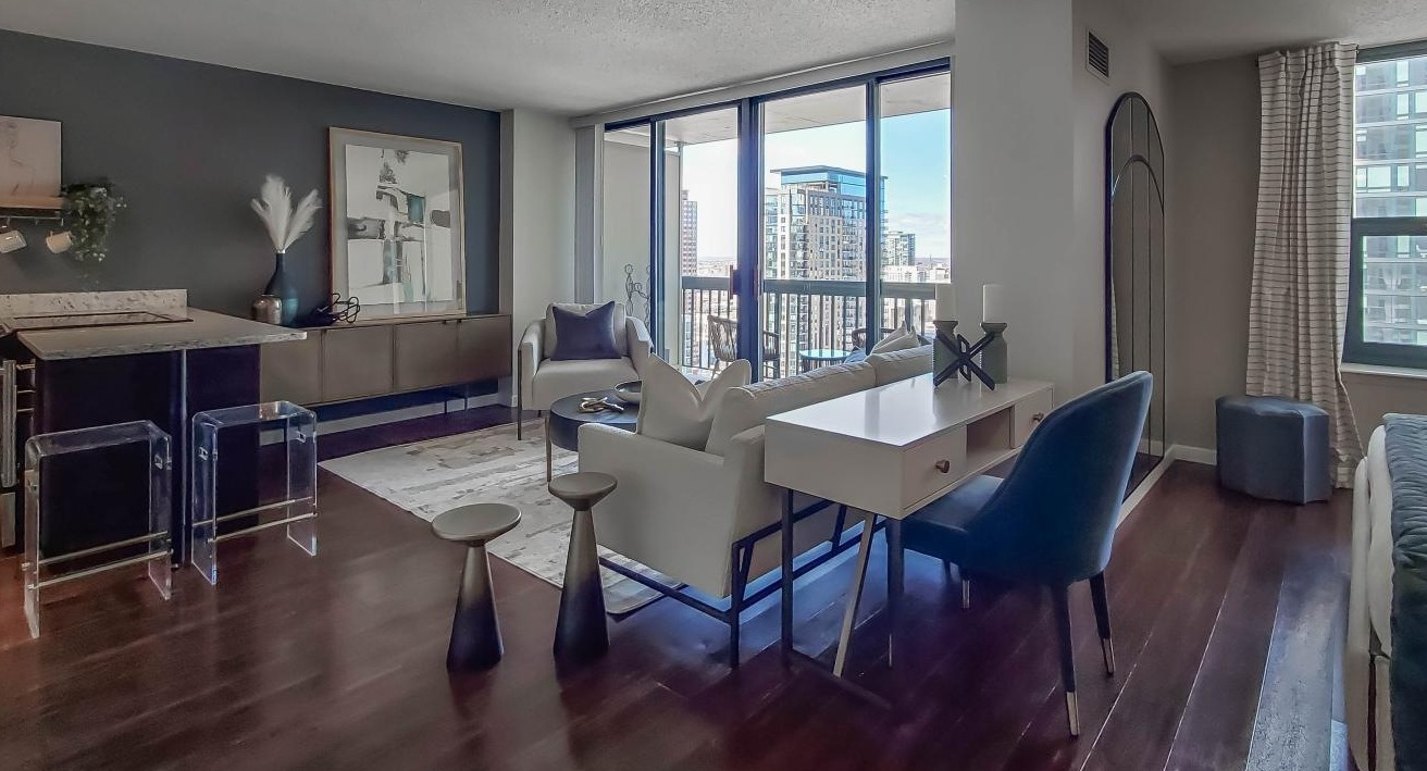 Open studio-style apartment at One Superior Place Apartments with kitchen island, living space, and bedroom area in a modern layout