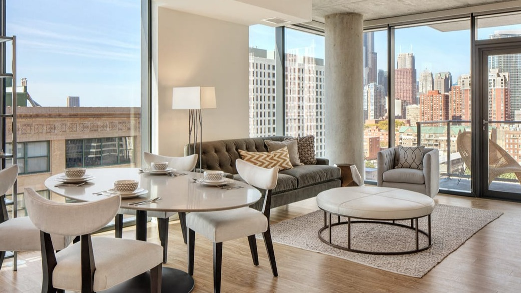 Cozy living and dining area with floor-to-ceiling windows, balcony access, and skyline views at ONE333 apartments in Chicago’s downtown
