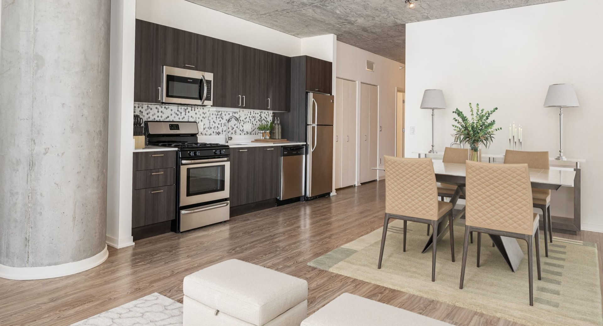 Spacious open-concept living and dining room with concrete ceilings, column, and modern kitchen at ONE333 apartments in Chicago