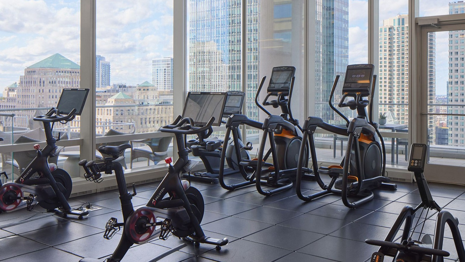 Bright cycle studio at OneEleven in Chicago, featuring modern bikes and expansive windows with city views for an inspiring workout