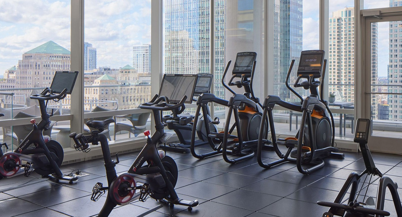 Bright cycle studio at OneEleven in Chicago, featuring modern bikes and expansive windows with city views for an inspiring workout