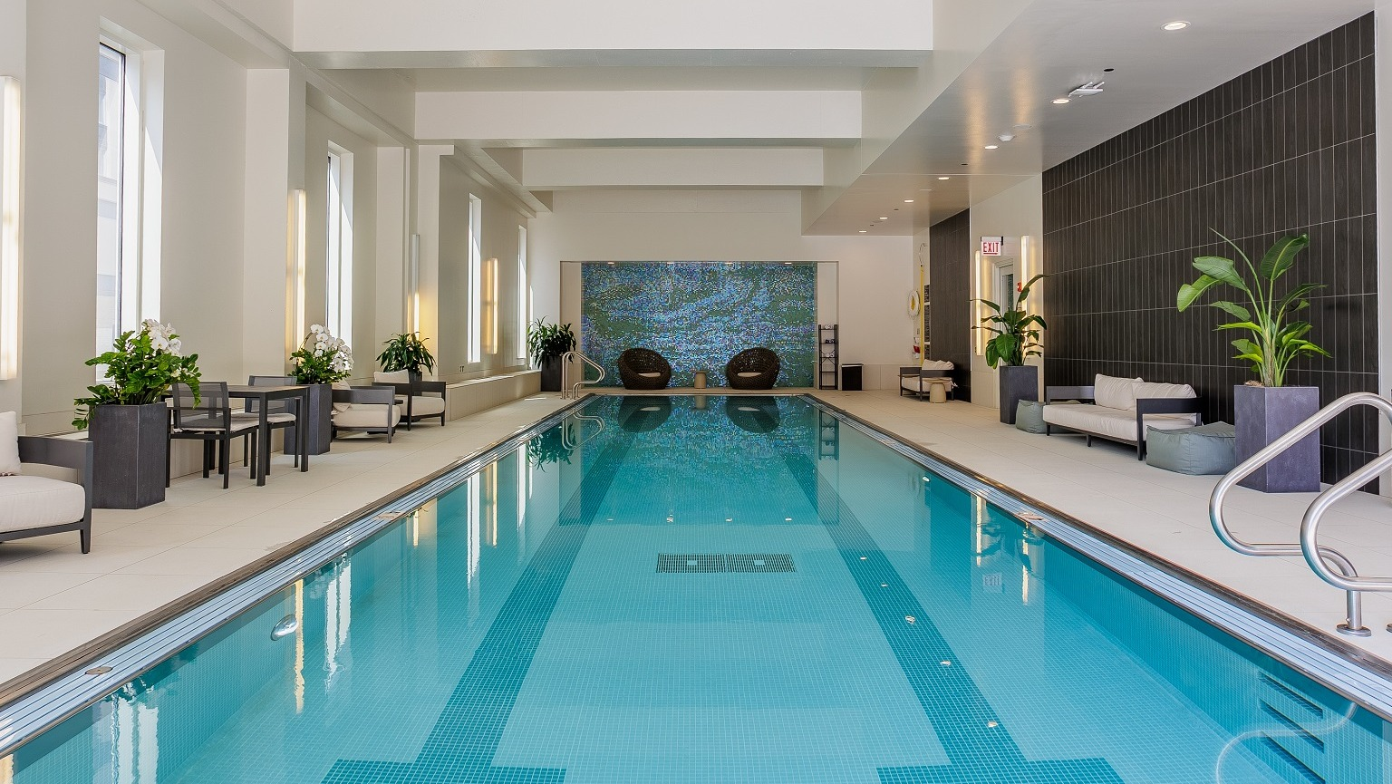 Serene indoor lap pool at OneEleven in Chicago, featuring clear blue water, comfortable seating areas, and ambient lighting