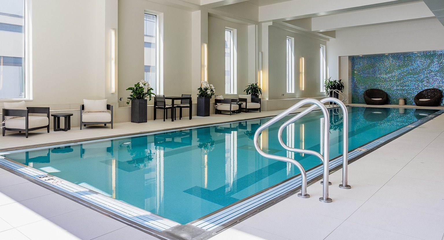 Inviting indoor pool area at OneEleven in Chicago, featuring a pristine lap pool, comfortable lounge seating, and large windows