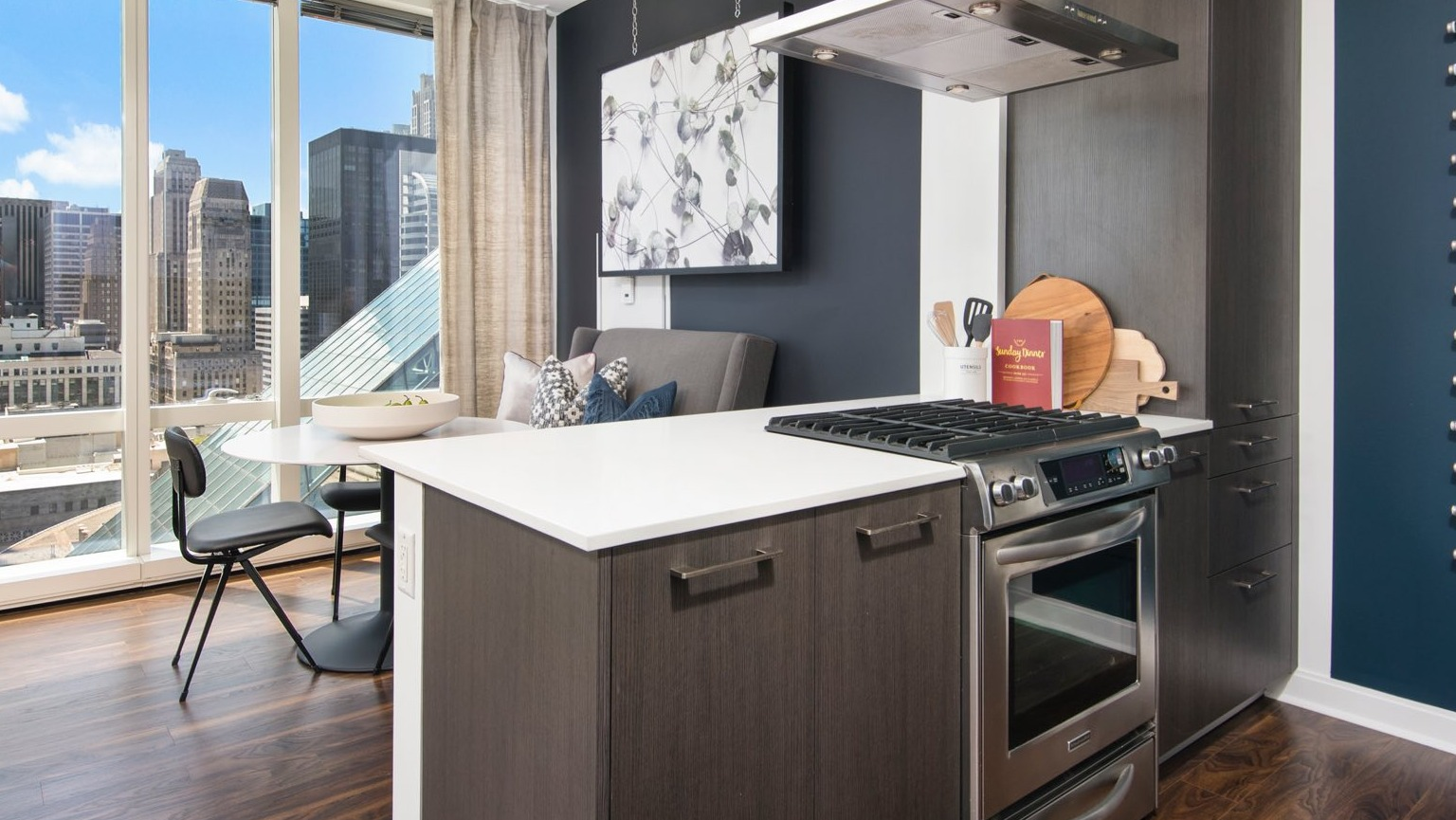 Contemporary apartment kitchen at OneEleven in Chicago, with a stylish island, modern appliances, and a dining area with city views
