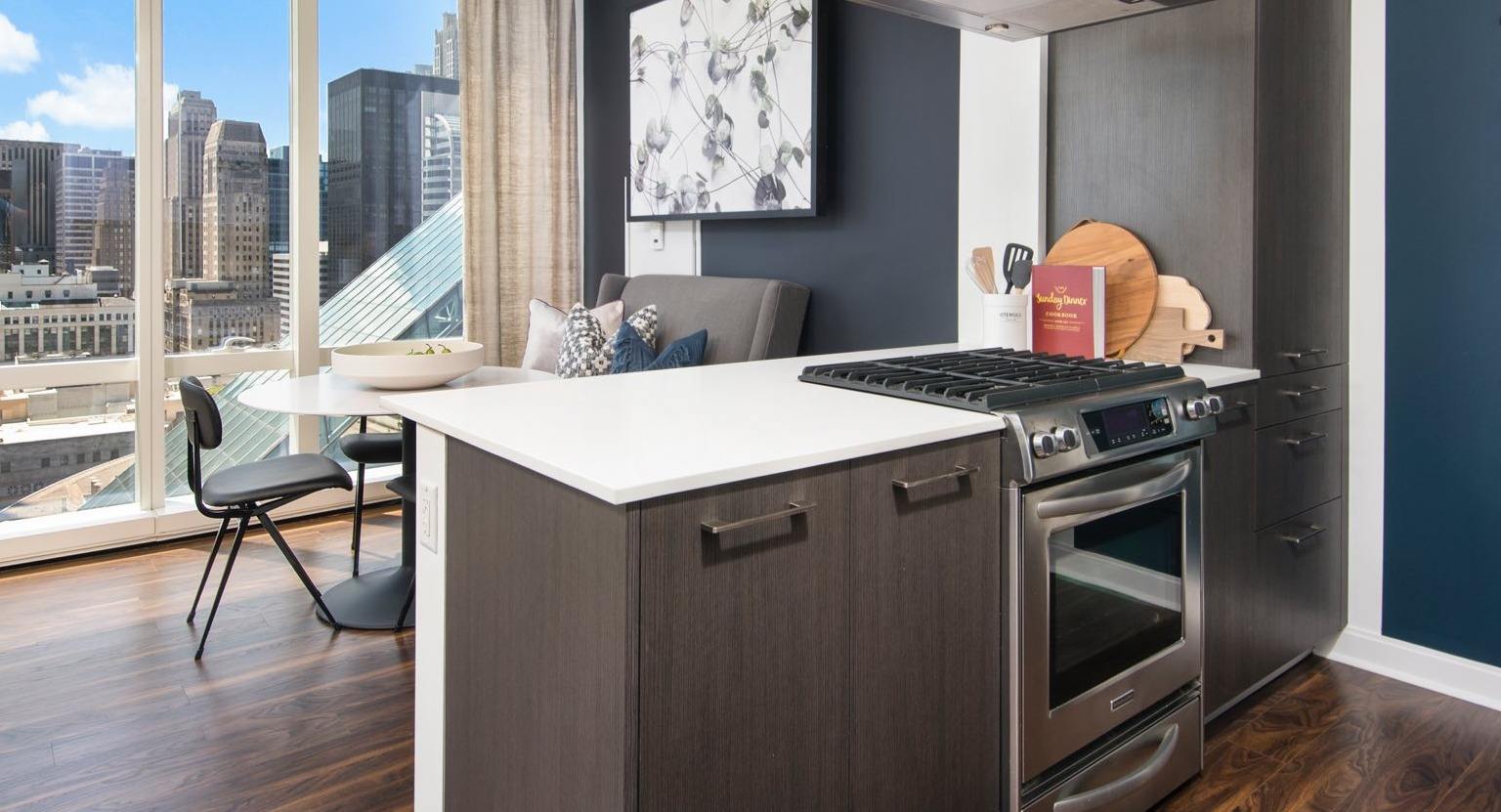 Contemporary apartment kitchen at OneEleven in Chicago, with a stylish island, modern appliances, and a dining area with city views