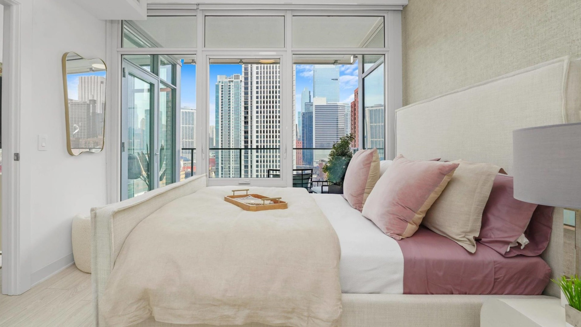 Luxurious bedroom at Onni Fulton Market in Chicago, featuring a large bed, stylish decor, and a private balcony with city views