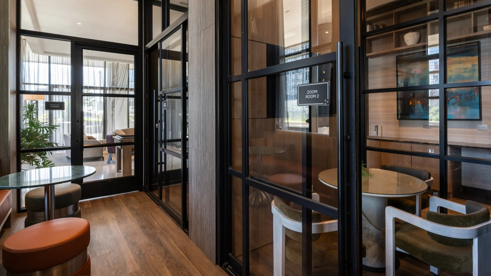 Modern co-working spaces at Onni Fulton Market in Chicago, featuring private "Zoom rooms" and collaborative seating for residents