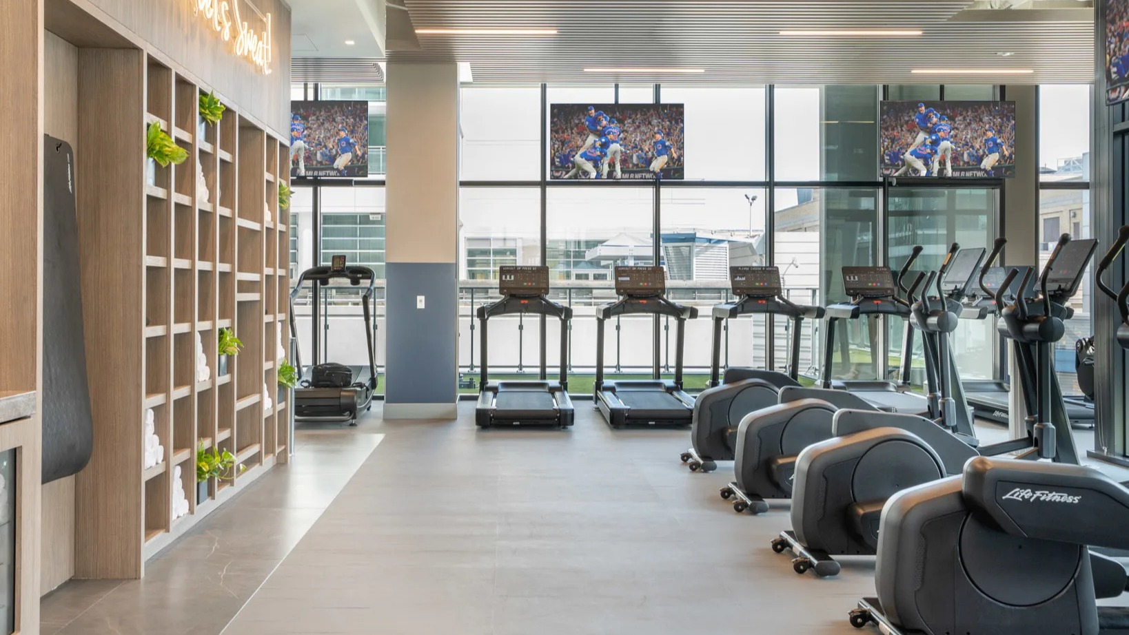 State-of-the-art fitness center at Onni Fulton Market in Chicago, featuring cardio machines, weight equipment, and large screens